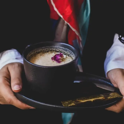 A cup of coffee with a flower on it